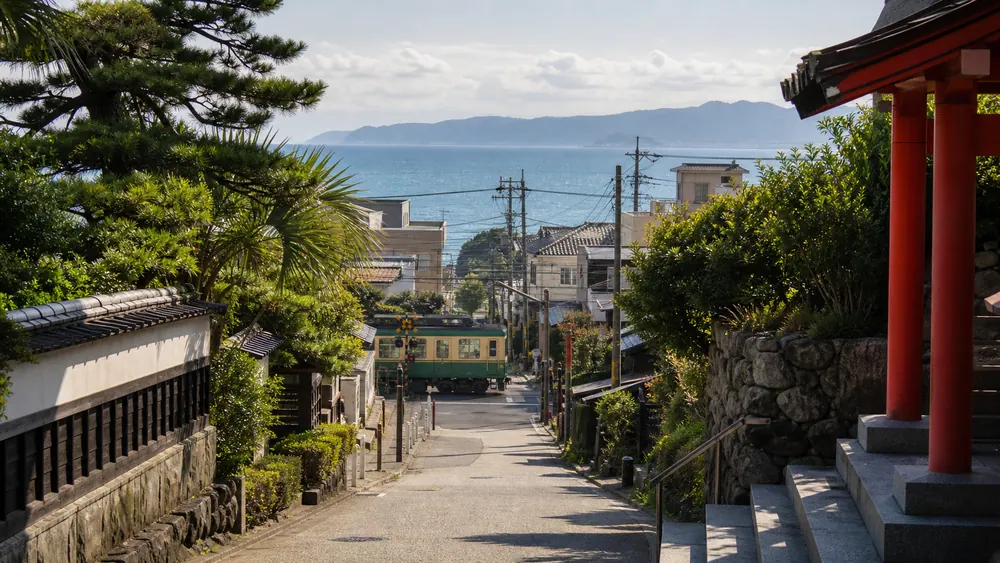 A local train passing through a Japanese coastal town